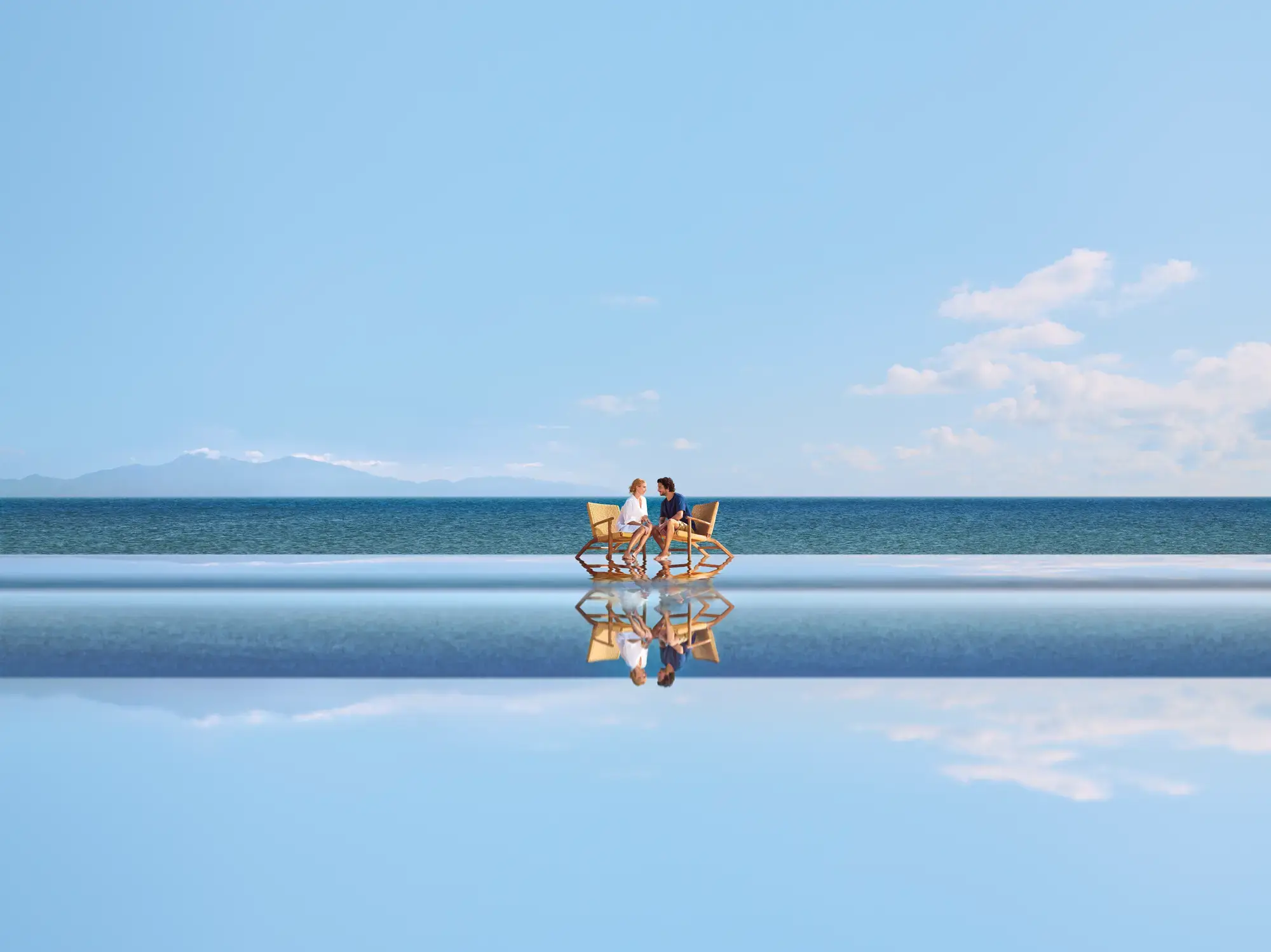 Seuls au monde - couple avec chaises sur l'eau