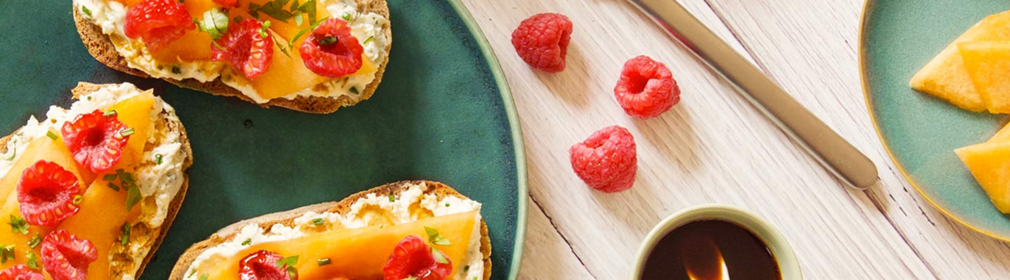 Tartines au fromage ail et fines herbes, melon et framboises