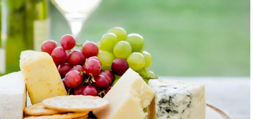 TH05_wooden-board-with-cheese-grapes-and-wine-in-the-background-picture-id117149898